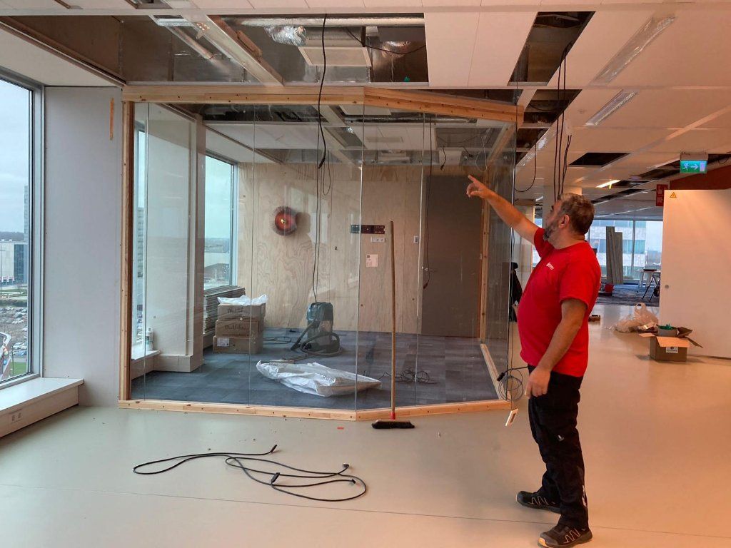 Montage van de glazen wand van een vergaderruimte tijdens de bouwfase van Floor Almere